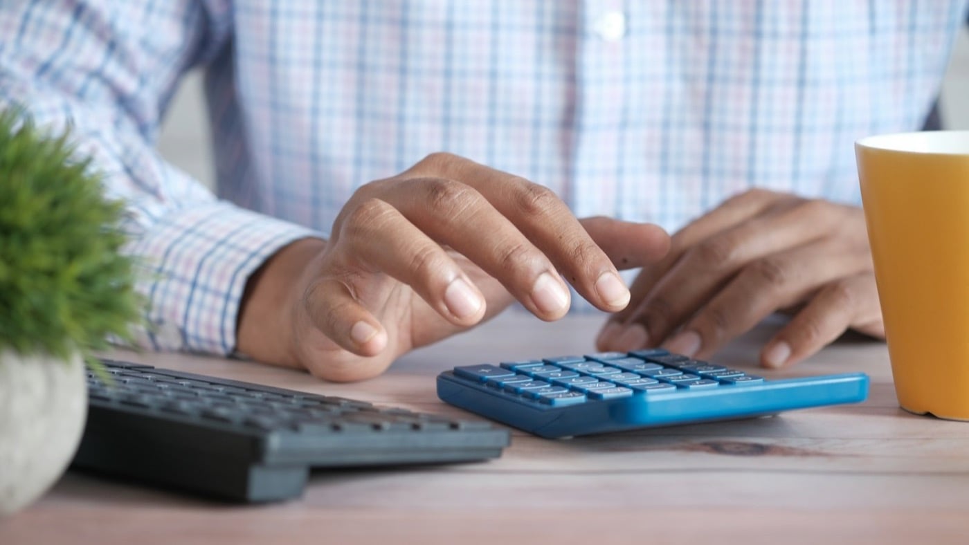 A person working through figures on a calculator at a desk
