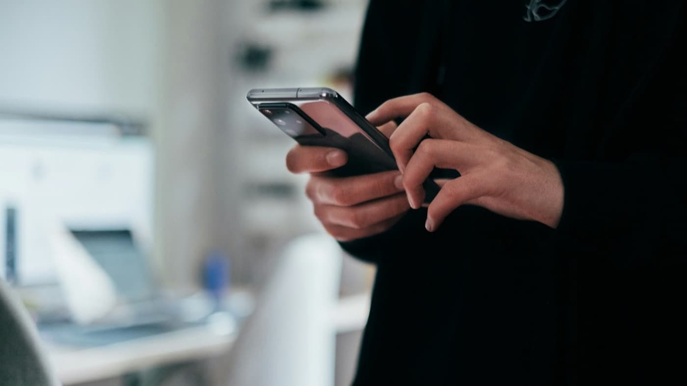 A person typing a message on a mobile phone
